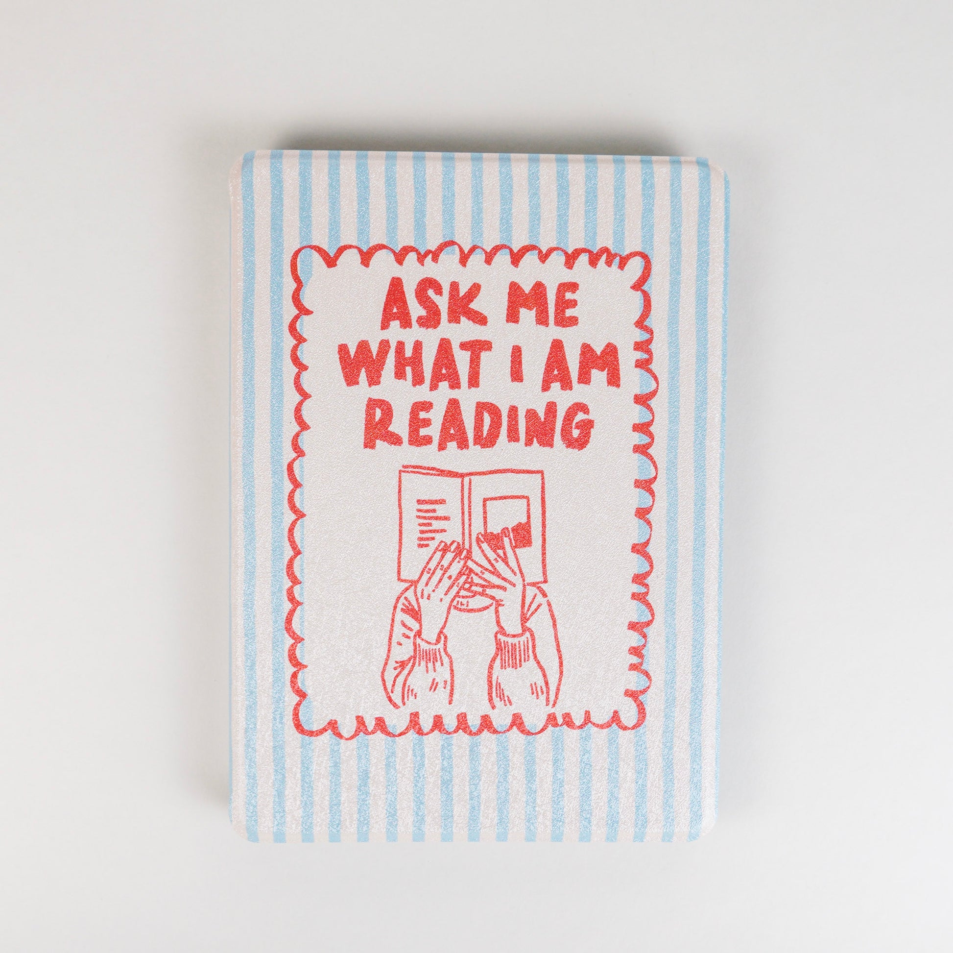 Page Turner Kindle Case with blue and beige stripes, red text that says ‘Ask Me What I Am Reading,’ and hands holding a book illustration by Elco House